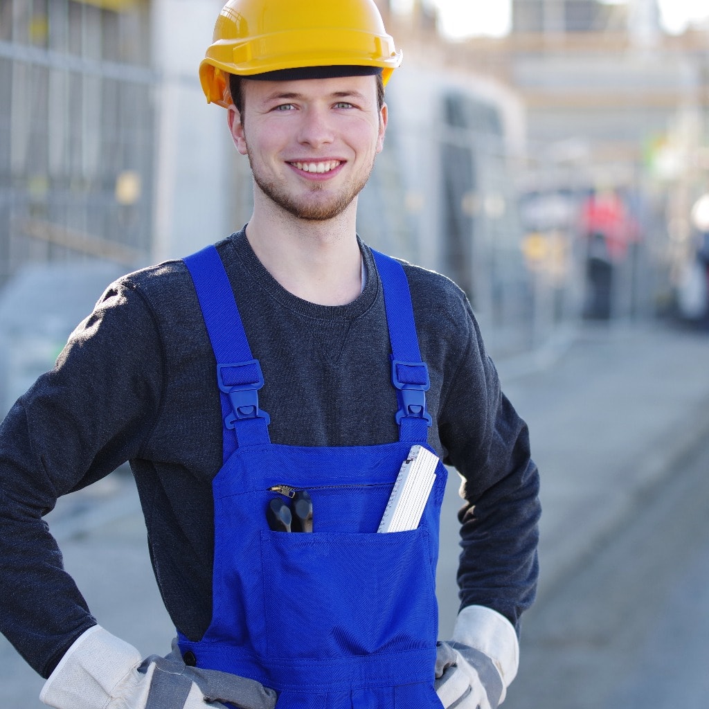 Handwerker mit nettem Lachen auf einer Baustelle